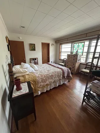 a bedroom with furniture and a large window