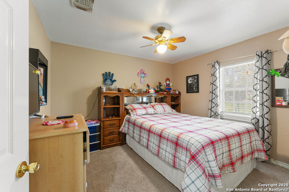2930 Shane Road San Antonio, TX 78223 - Photo 30 of 75 a bedroom with a bed and a chandelier