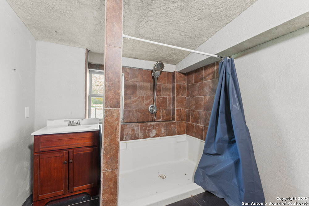 2930 Shane Road San Antonio, TX 78223 - Photo 39 of 75 a bathroom with a sink a mirror and shower