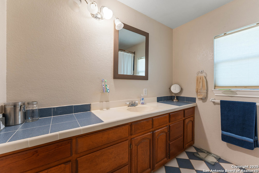 2930 Shane Road San Antonio, TX 78223 - Photo 49 of 75 a bathroom with a sink and a mirror