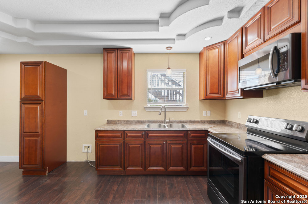 2930 Shane Road San Antonio, TX 78223 - Photo 7 of 75 a kitchen with stainless steel appliances granite countertop a sink a stove a microwave and wooden floors