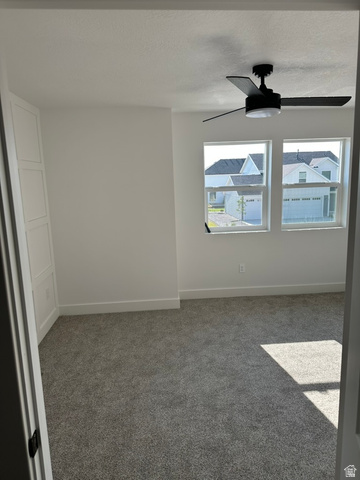 1886 North 300 West Logan, UT 84341 - Photo 18 of 18 Bright room featuring two windows, a ceiling fan, plush gray carpeting, and a built-in white cabinet with panel detailing