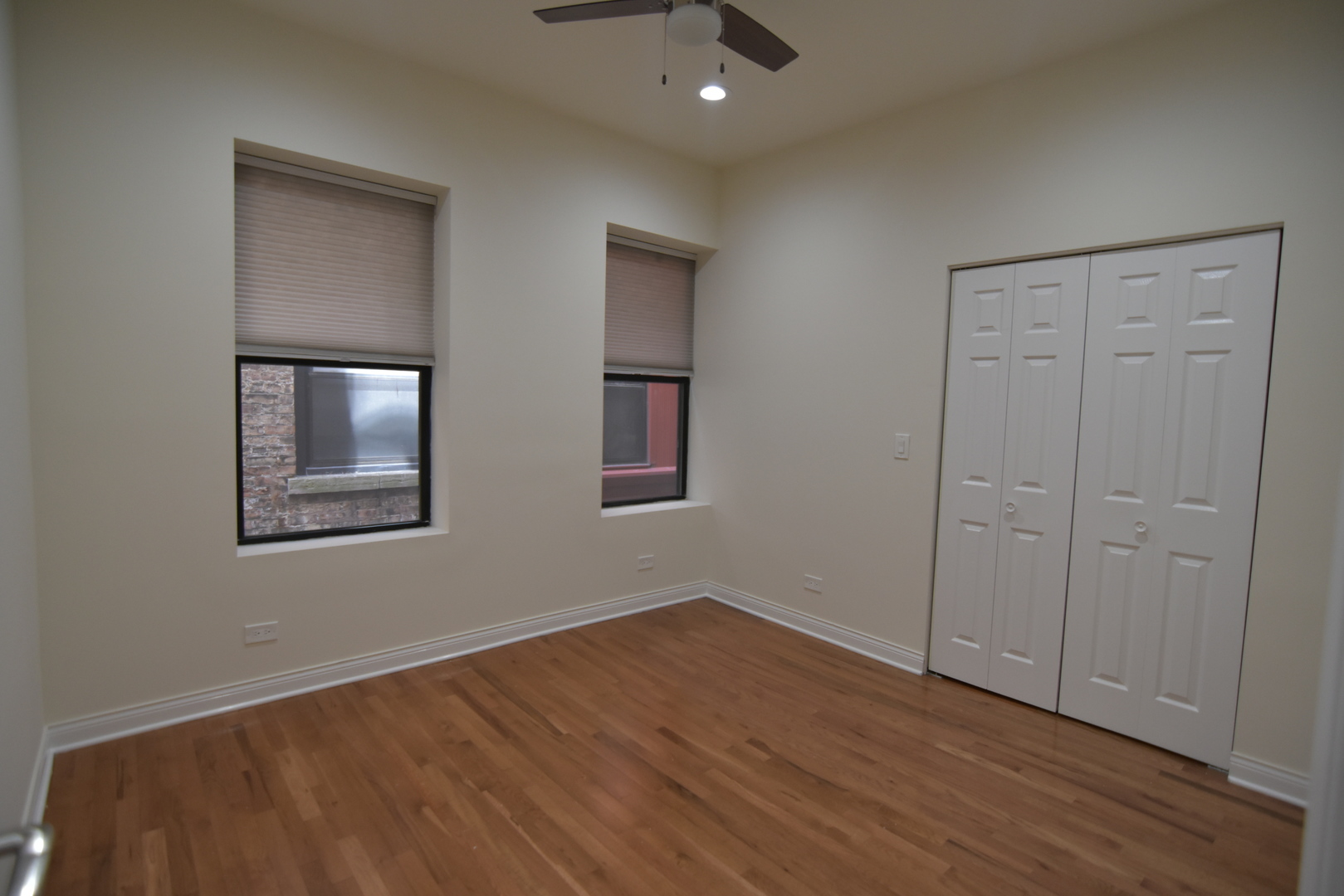 732 West Grace Street, Unit 2W Chicago, IL 60613 - Photo 13 of 15 a view of an empty room with wooden floor and a ceiling fan