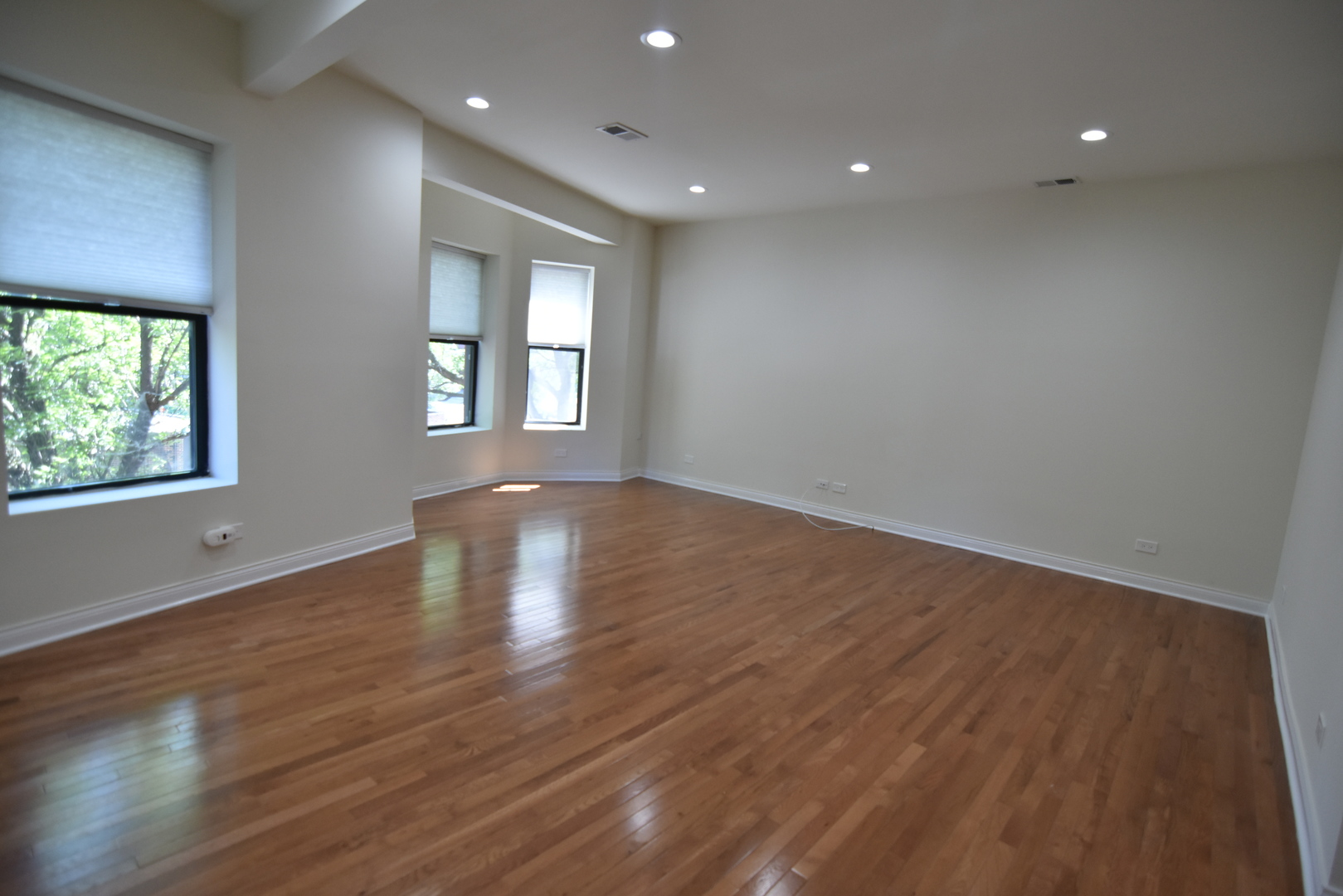 732 West Grace Street, Unit 2W Chicago, IL 60613 - Photo 6 of 15 an empty room with wooden floor and windows