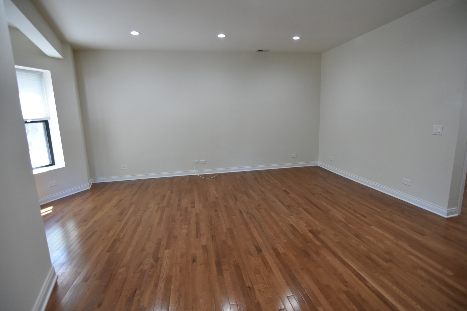 732 West Grace Street, Unit 2W Chicago, IL 60613 - Photo 7 of 15 an empty room with wooden floor and windows