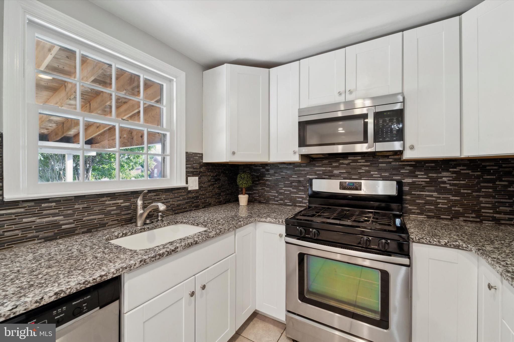 1718 Mt Pleasant Road Havertown, PA 19083 - Photo 8 of 30 a kitchen with granite countertop a stove a sink and a microwave