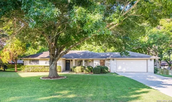 a front view of a house with a garden and trees