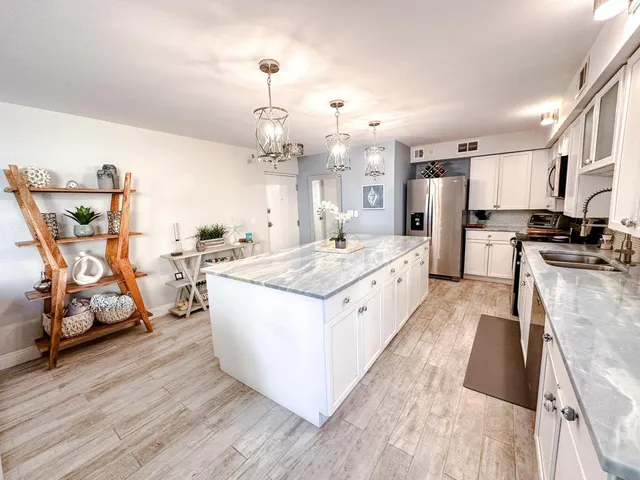 a large white kitchen with stainless steel appliances