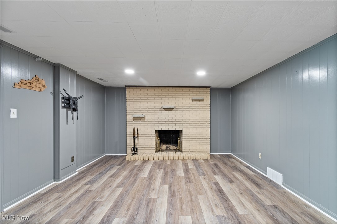 515 Oneida Avenue Northwest Canton, OH 44708 - Photo 24 of 28 Unfurnished living room with wood finished floors, a fireplace, and wood walls