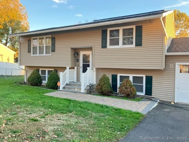 a front view of a house with a yard and potted plants
