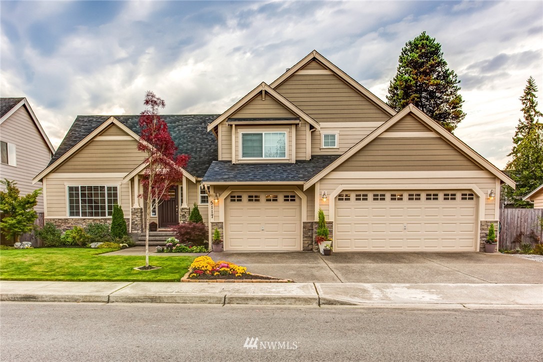5117 Northeast 11th Street Renton, WA 98059 - Photo 1 of 19 a front view of a house with a yard and garage