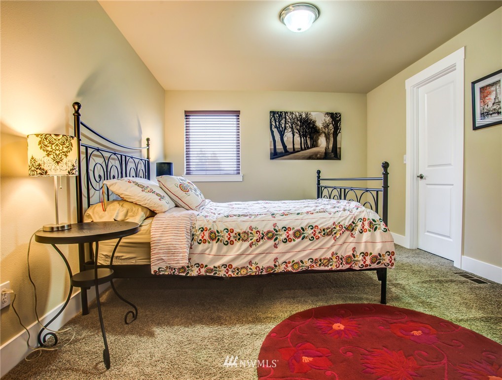 5117 Northeast 11th Street Renton, WA 98059 - Photo 15 of 19 a bedroom with a bed a chair and potted plant on the table