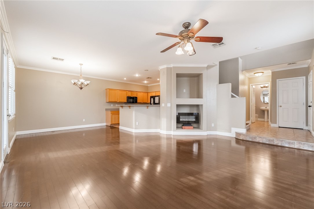 224 Positive Point Street Henderson, NV 89012 - Photo 7 of 44 Polished wood flooring and an open layout connect the living area to the kitchen.
