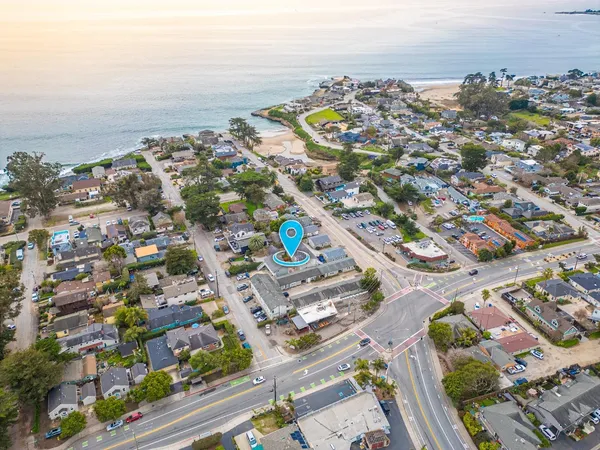 an aerial view of a city with lots of residential buildings and ocean view in back