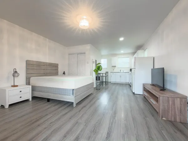 a spacious bedroom with a bed and a wooden floor