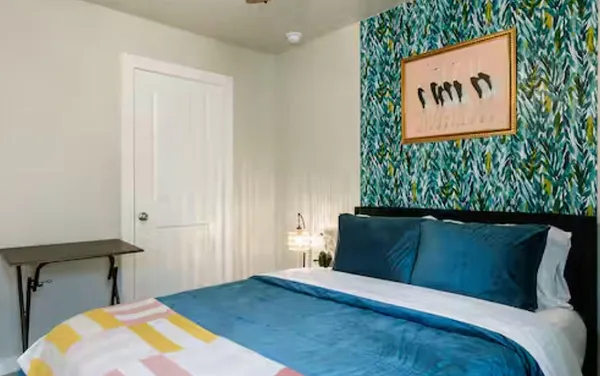 a bedroom with a bed and a painting on the wall