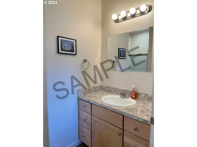 a bathroom with a granite countertop sink a mirror and vanity