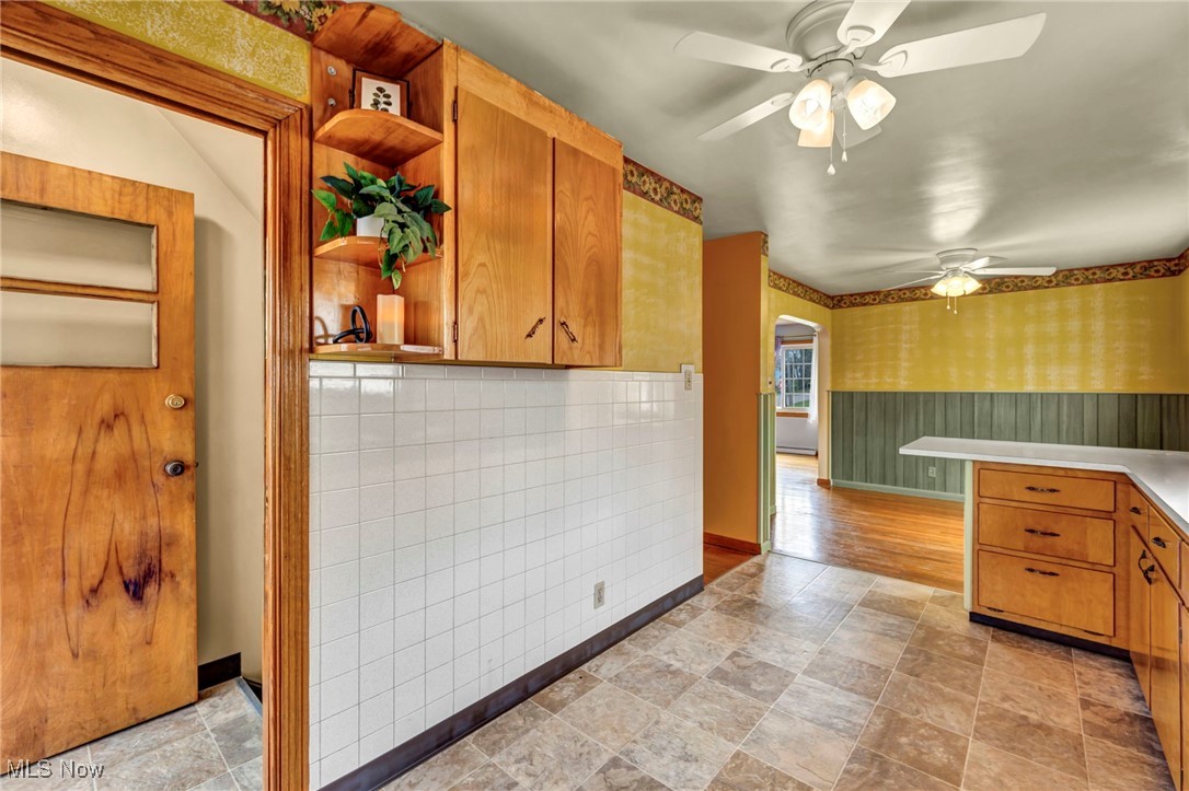 367 High Grove Boulevard Akron, OH 44312 - Photo 17 of 46 Kitchen with baseboards, wallpapered walls, stone finish floor, ceiling fan, and open shelves