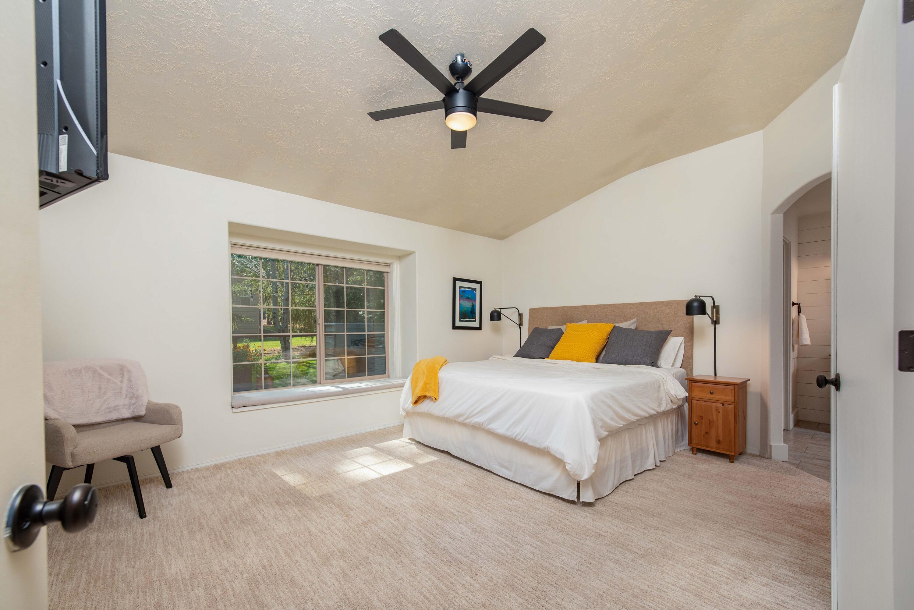 2701 Northwest Strath Way Bend, OR 97703 - Photo 18 of 41 Double doors open to the primary bedroom and bath located in it's own corner of the home, beautiful picture window with views to the backyard.