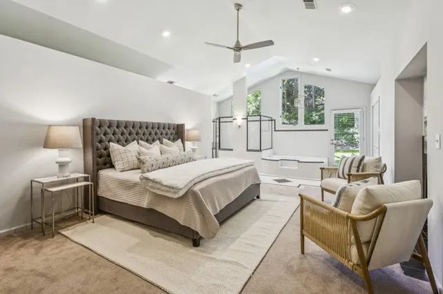 a bedroom with a bed a chair and potted plant on the table