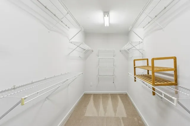 an empty room with windows and chandelier fan