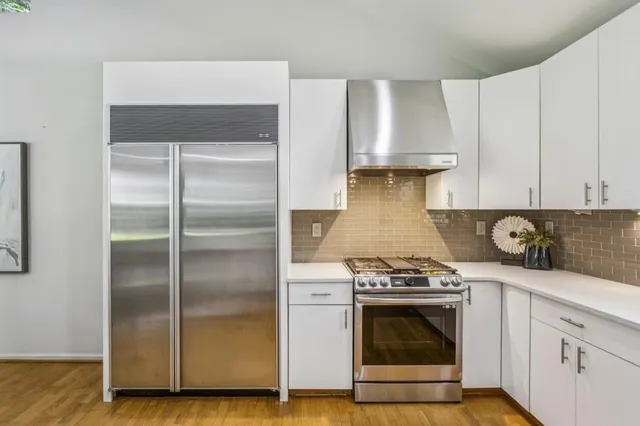 a kitchen with granite countertop a stove and a wooden floor