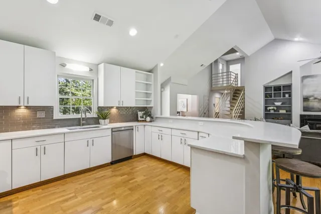 a large white kitchen with lots of counter space and chandelier