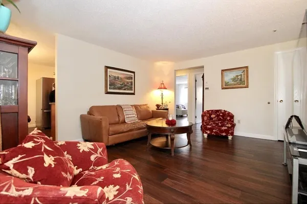 a living room with furniture rug and wooden floor