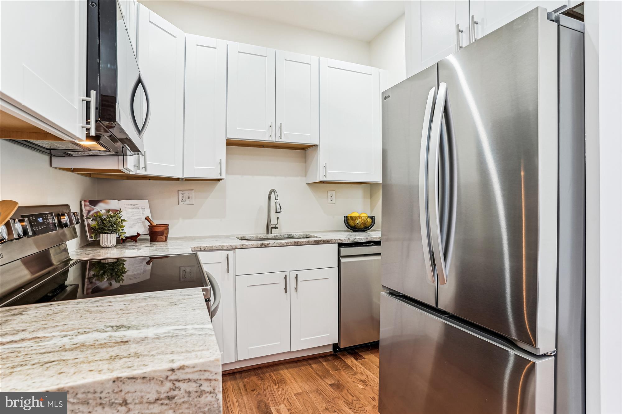 1615 Q Street Northwest, Unit 1012 Washington, DC 20009 - Photo 12 of 39 a kitchen with stainless steel appliances granite countertop a refrigerator a sink and white cabinets