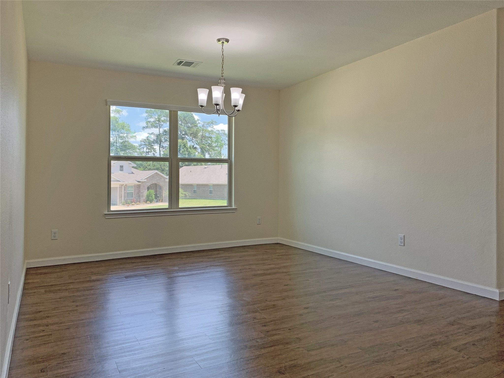 5612 Rainflower Terrace Lane Spring, TX 77389 - Photo 13 of 50 an empty room with wooden floor chandelier and windows