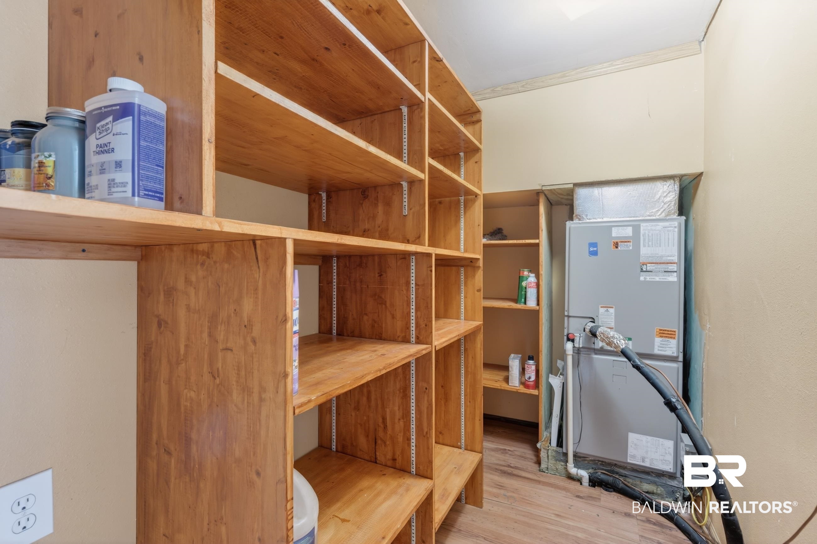 24903 Patterson Road Robertsdale, AL 36567 - Photo 57 of 57 Built-in wood-finish shelving with adjustable shelves, wood-finish flooring, and a recessed HVAC unit