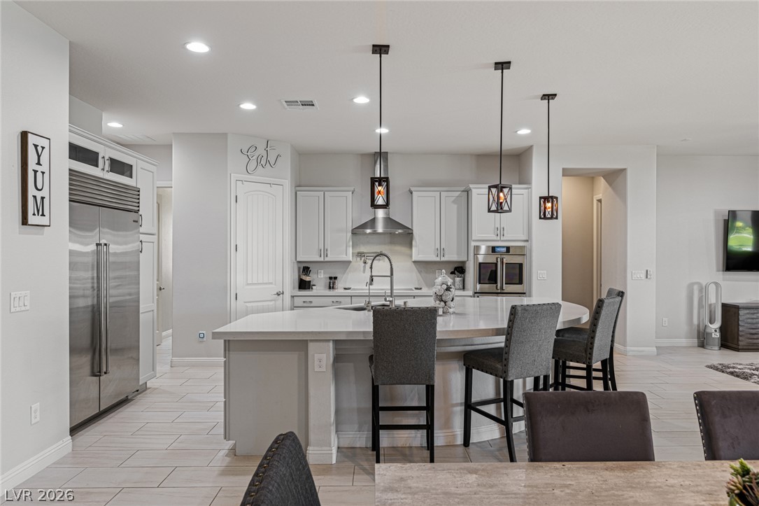 7036 Arabian Ridge Street Las Vegas, NV 89131 - Photo 25 of 64 A sleek kitchen island provides ample counter space, complemented by modern stainless steel appliances.
