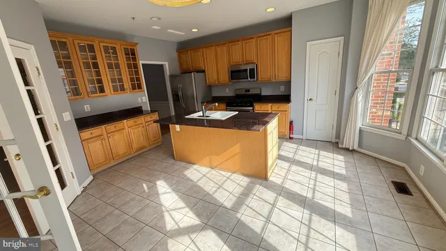 a kitchen with stainless steel appliances a stove a refrigerator a sink a microwave oven and cabinets
