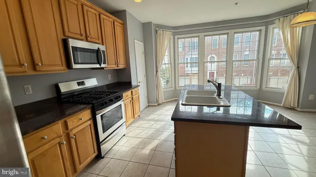 a kitchen with granite countertop a sink and a stove top oven