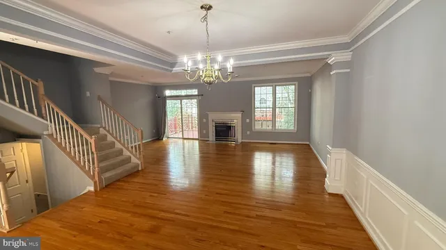 a view of a room with wooden floor fireplace and windows