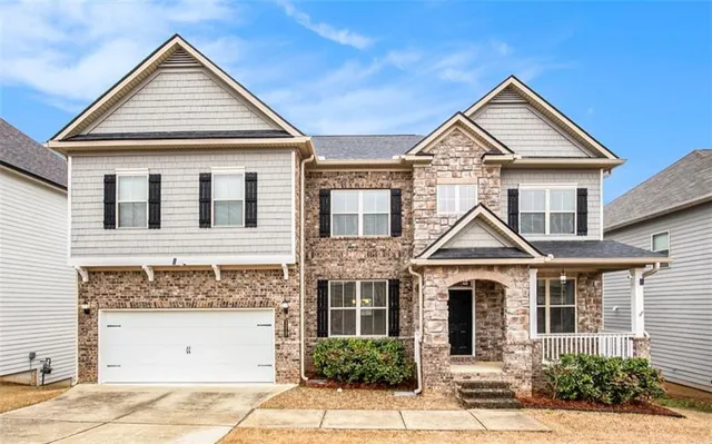 a front view of a house with a yard and garage