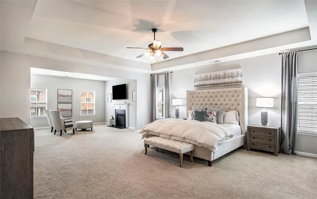a bedroom with a bed couch and a ceiling fan