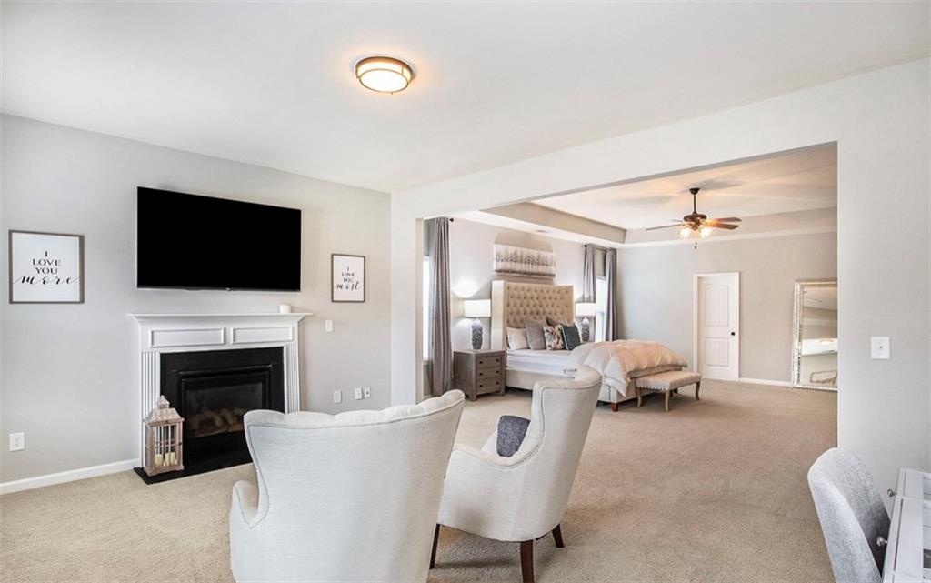 3217 Bowlin Drive Fairburn, GA 30213 - Photo 14 of 28 a living room with furniture a fireplace and a flat screen tv