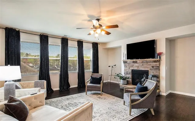 a living room with furniture a flat screen tv and a fireplace