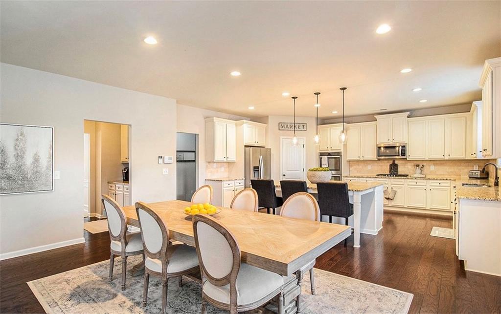 3217 Bowlin Drive Fairburn, GA 30213 - Photo 8 of 28 a dining room with stainless steel appliances kitchen island granite countertop a dining table chairs and a refrigerator