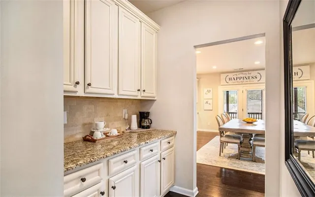 a kitchen with granite countertop white cabinets and white appliances