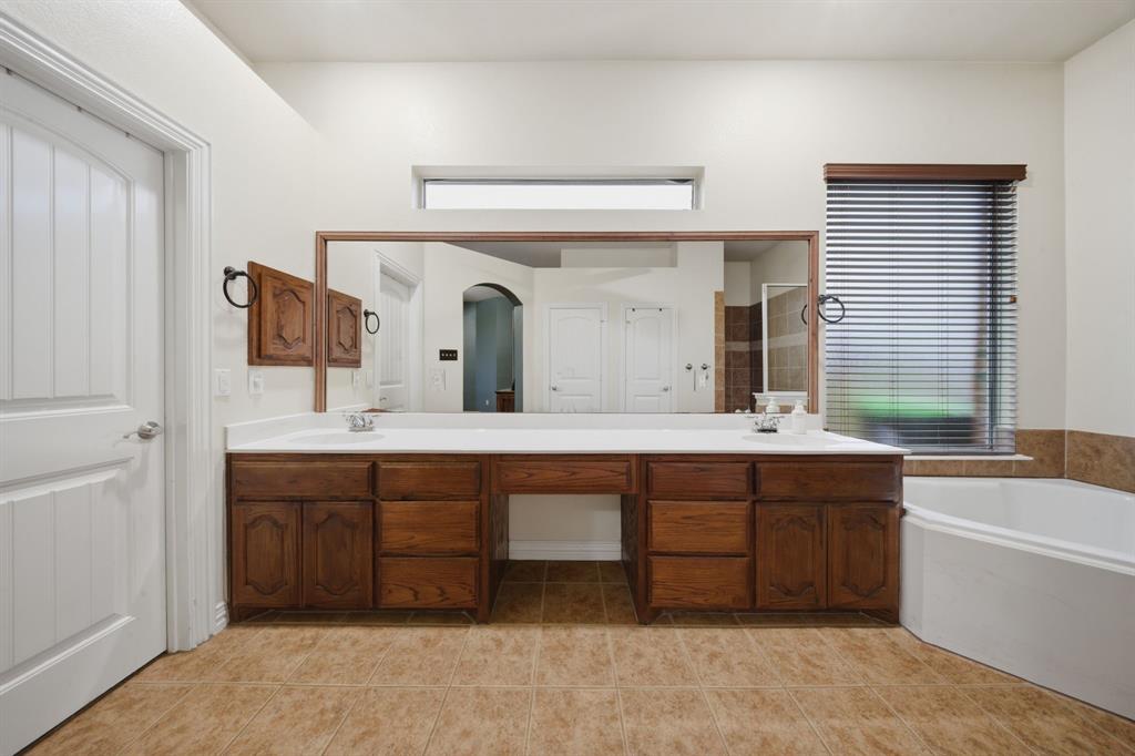 603 Cedar Drive Pilot Point, TX 76258 - Photo 19 of 39 Expansive dual-sink vanity with wood cabinetry, white countertops, and a large wall-mounted mirror