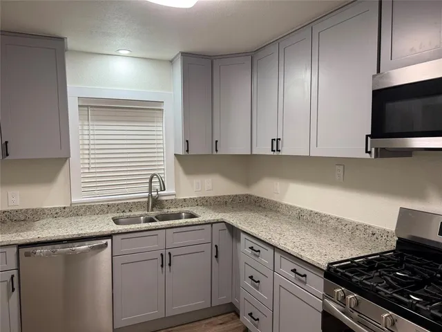 a kitchen with granite countertop a sink and a stove