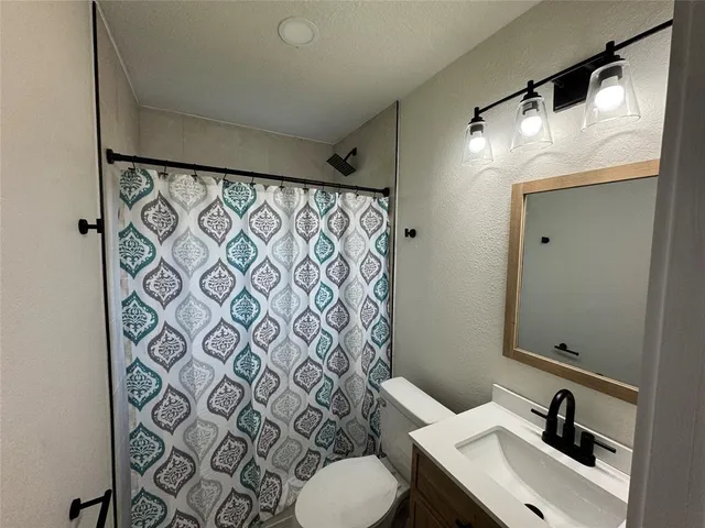 a bathroom with a sink and mirror with toilet