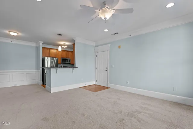 a kitchen with a refrigerator and dining table with wooden floor