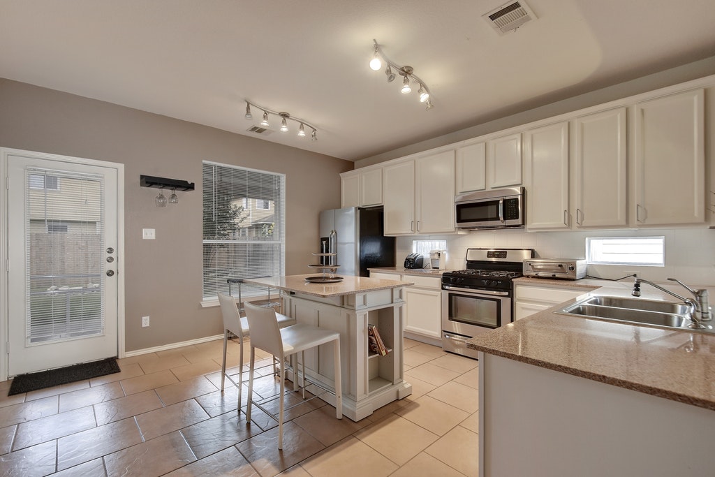 2201 Keepsake Drive Austin, TX 78745 - Photo 7 of 25 a kitchen with stainless steel appliances granite countertop a refrigerator and microwave