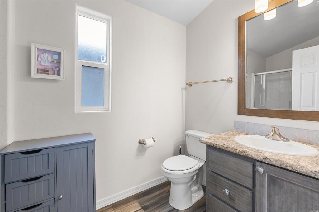 8545 Mission Gorge Road, Unit 253A Santee, CA 92071 - Photo 13 of 21 a bathroom with a granite countertop toilet a sink and a mirror