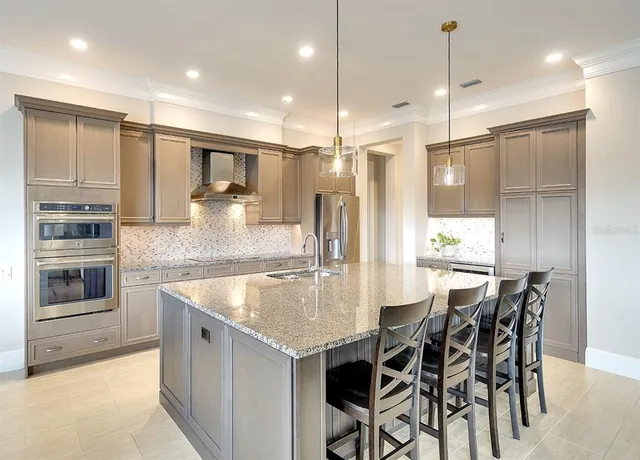 a kitchen with stainless steel appliances granite countertop a kitchen island a stove and a sink