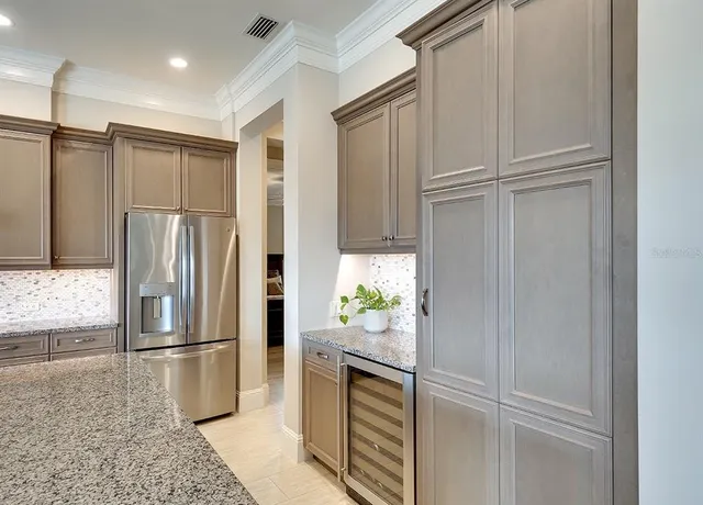 a kitchen with stainless steel appliances granite countertop a refrigerator and a sink