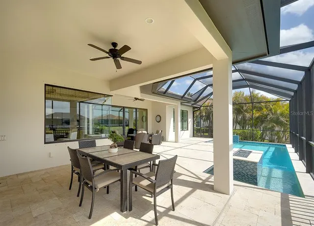a dining room with furniture a rug and a floor to ceiling window